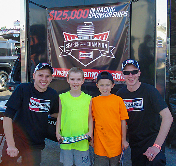 Corey and Kyle Michalek pose with two future racers at the 2013 Cavalcade of Stars race at Summit Racing Equipment Motorsports Park in Norwalk, Ohio